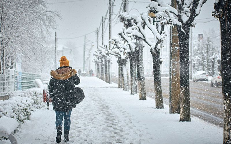 a person walking through a blizzard on a street