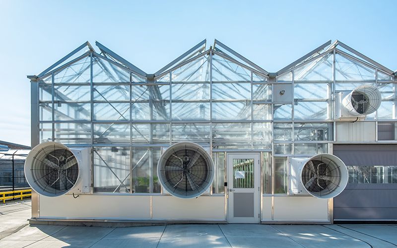 a greenhouse with fans outside