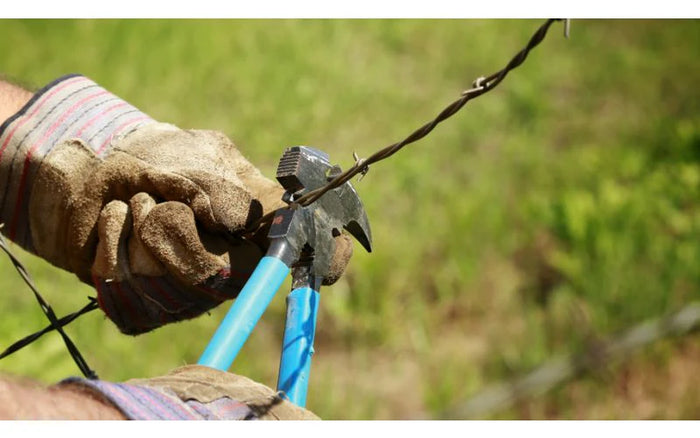 worker repairing fence with tools